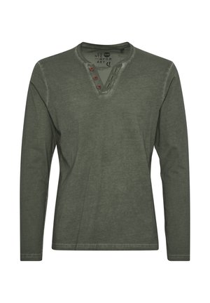 Maglietta a maniche lunghe verde oliva in cotone. Presenta un colletto henley con tre bottoni marroni e una finitura texturizzata. Il design include una leggera scoloritura.
