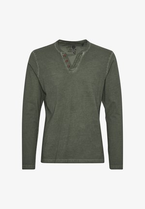 Olijfgroene T-shirt met lange mouwen van katoen. Voorzien van een henley-halslijn met drie bruine knopen en een gestructureerde afwerking. Ontwerp bevat een lichte vervaging.