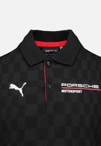Czarny koszulka polo w kratę z czerwonym akcentem i kołnierzykiem. Zawiera białe logo Pumy oraz tekst "PORSCHE MOTORSPORT" w białym i czerwonym kolorze.