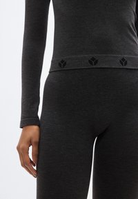 Σκούρο γκρι θερμικό σετ που περιλαμβάνει μπλούζα με μακριά μανίκια και στρογγυλεμένο λαιμόκοψη, καθώς και στενά παντελόνια με ελαστική μέση διακοσμημένη με λογότυπο.