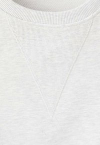 Světle šedá bavlněná mikina s žebrovanou texturou. Na výstřihu je trojúhelníkový prvek jako designový detail.