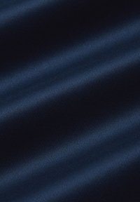 Granatowy materiał o gładkiej, błyszczącej fakturze i subtelnym, skośnym prążkowaniu, ukazujący miękkie fałdy i odbicia światła.