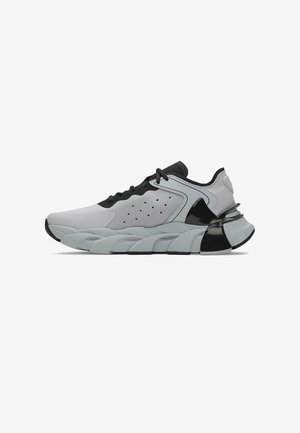 Baskets de sport grises et noires avec une semelle sculptée, un panneau latéral perforé et un système de laçage, présentées en profil latéral.