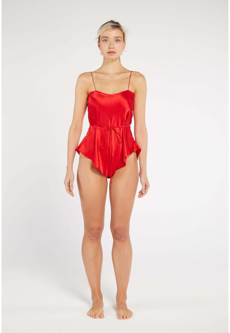 Red satin romper with a relaxed fit, featuring thin shoulder straps and a belted waist. The fabric has a smooth, glossy texture.