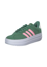 Zelene nubuk tenisice s bijelim potplatom, sa ružičastim trostrukim trakama i podstavljenim ovratnikom. Glatka tekstura s oblikom zaobljenog vrha.