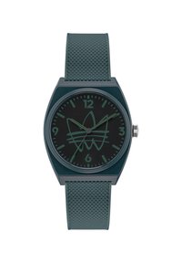 Montre en silicone verte avec un bracelet texturé, dotée d'un cadran noir et de repères horaires minimalistes, accentuée par un design de logo subtil.