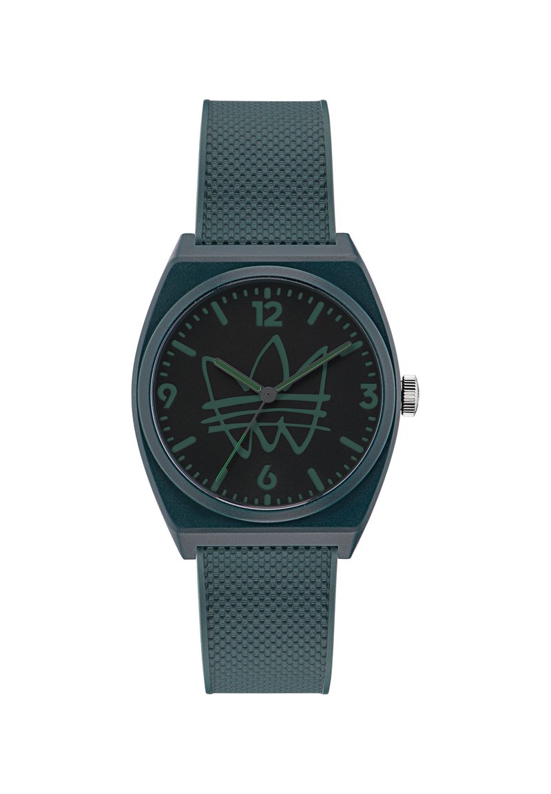 Montre en silicone verte avec un bracelet texturé, dotée d'un cadran noir et de repères horaires minimalistes, accentuée par un design de logo subtil.