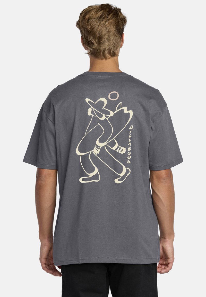 Grå kortærmet t-shirt med et stort beige grafik af en person, der holder et surfbræt, med afrundede kanter og en afslappet pasform.