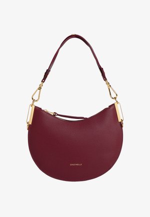 Sac à main en cuir bourgogne de forme demi-lune, avec des accents en matériel doré et une fermeture éclair. Dispose d'une courte bandoulière pour le transport.