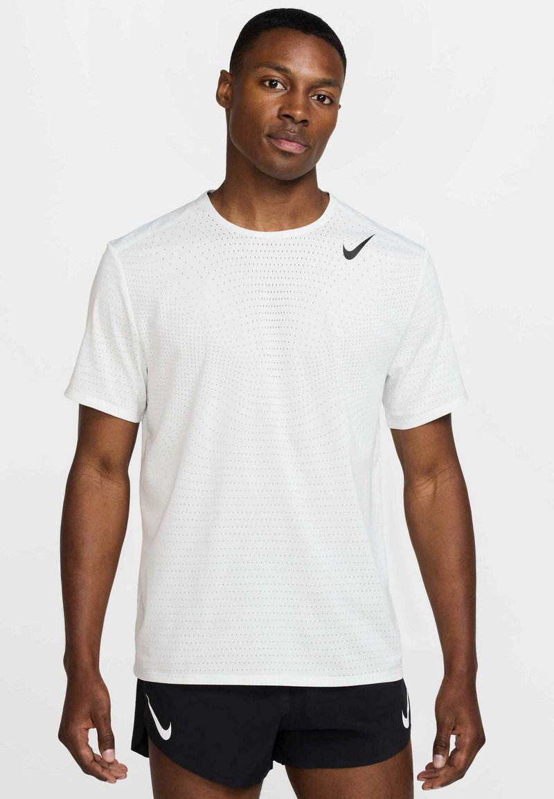 Λευκό αθλητικό t-shirt με κοντά μανίκια, διαπεραστό σχέδιο, στρογγυλή λαιμόκοψη και μαύρο λογότυπο Nike στον αριστερό ώμο.