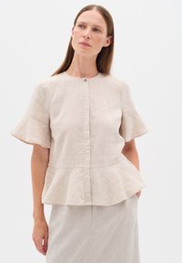 Beige lněná blůza s krátkými zvonovými rukávy a peplum lemem, která má u výstřihu knoflíkové zapínání pro strukturovaný design.