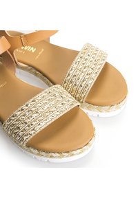 Kultavärjättyjä plateau-sandaaleja, joissa on vaaleanruskeasta nahasta valmistetut hihnat, tekstuurilla varustettu yläosa, paksu pohja ja kontrastiväriset valkoiset reunukset.