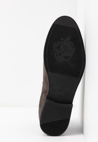 Brown suede ankle boot with a rubber sole. Features a smooth finish, subtle stitching detail, and embossed logo on the sole. Size 37.