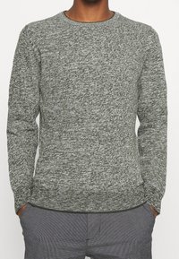 Grauer und dunkelgrüner gestrickter Pullover mit langen Ärmeln und rundem Ausschnitt. Der Stoff hat ein strukturiertes, meliertes Muster.