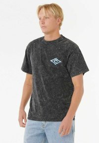 Camiseta de algodón negra de manga corta con un acabado desgastado, con un logo de diamante azul en el área del pecho izquierdo. Diseño clásico de cuello redondo.