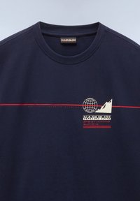 Camiseta de algodón azul marino con cuello redondo, diseño gráfico con un globo y una montaña, acentuada con texto en rojo y blanco.