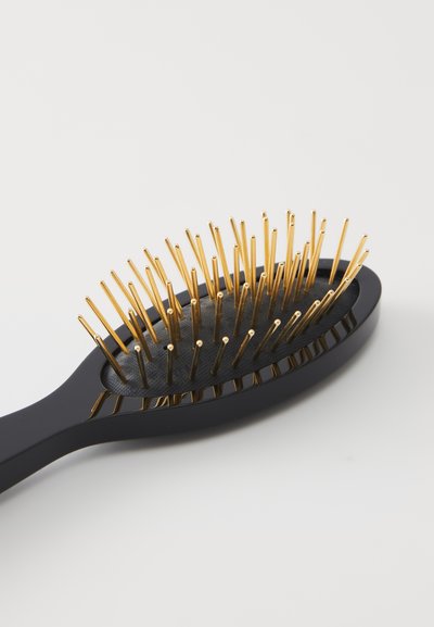 Βούρτσα ξεμπερδέματος με μαύρη λαβή και υφασμένη βάση. Χρυσαφένιες μεταλλικές τρίχες τοποθετημένες ομοιόμορφα σε μαύρο καουτσούκ στο κέντρο.