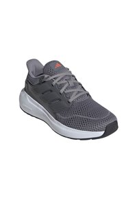 Zapatilla deportiva gris con parte superior de malla, acentos grises, puntera redondeada y suela blanca de Cloudfoam. Presenta un diseño de tres rayas en el costado.
