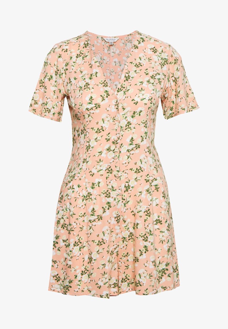 Robe courte à manches courtes couleur pêche avec imprimé floral blanc, encolure en V, fermeture à boutons sur le devant, et taille cintrée s'évasant en une jupe courte.