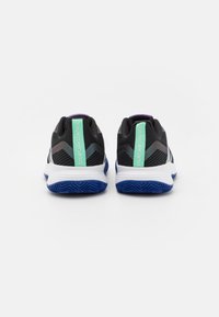 Černé sportovní boty s síťovinovým svrškem, fialovými a tyrkysovými akcenty, bílou mezipodešví a modrou texturovanou podrážkou. Zadní značení: "COURT JAM CONTROL."