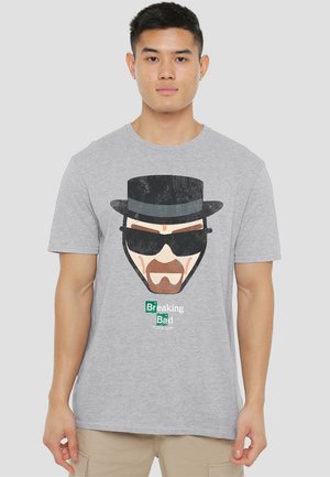 Gray cotton t-shirt featuring a printed graphic of a man in a black hat and sunglasses, labeled "Breaking Bad" at the bottom.