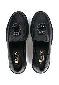 Para czarnych skórzanych loafersów z teksturowanej skóry z okrągłym czarnym koralikowym i metalowym pierścieniem na górze, z wkładkami marki HEGOS MILANO.