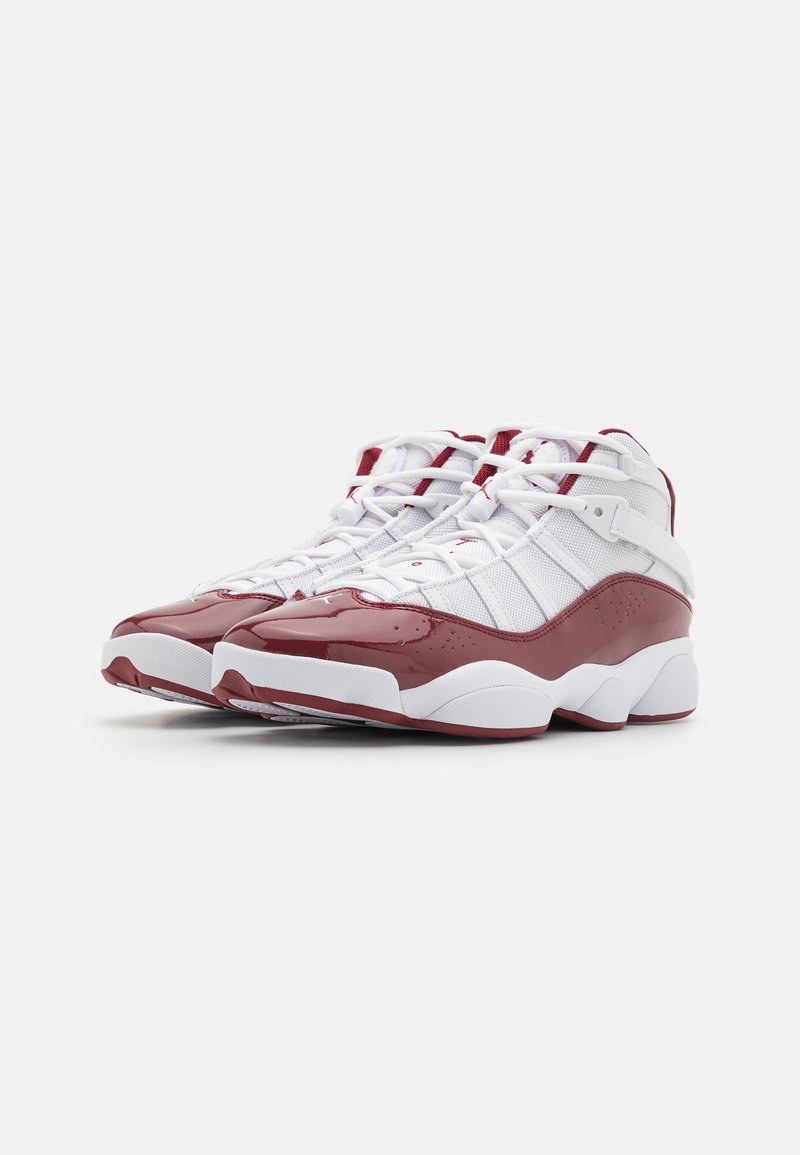 Baskets de sport montantes avec une tige en mesh blanc et des accents en cuir verni bordeaux, laçage décoratif et semelle texturée.