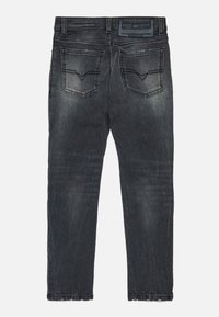 Džínsy z denimu v tmavošedej umývanej farbe, s päť vreckami, miernym vyblednutím a charakteristickými švy na zadných vreckách.