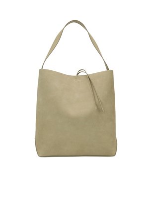 Sac en suède beige avec une texture lisse, large bandoulière et design minimaliste. Doté d'une discrète fermeture à cordon en haut.
