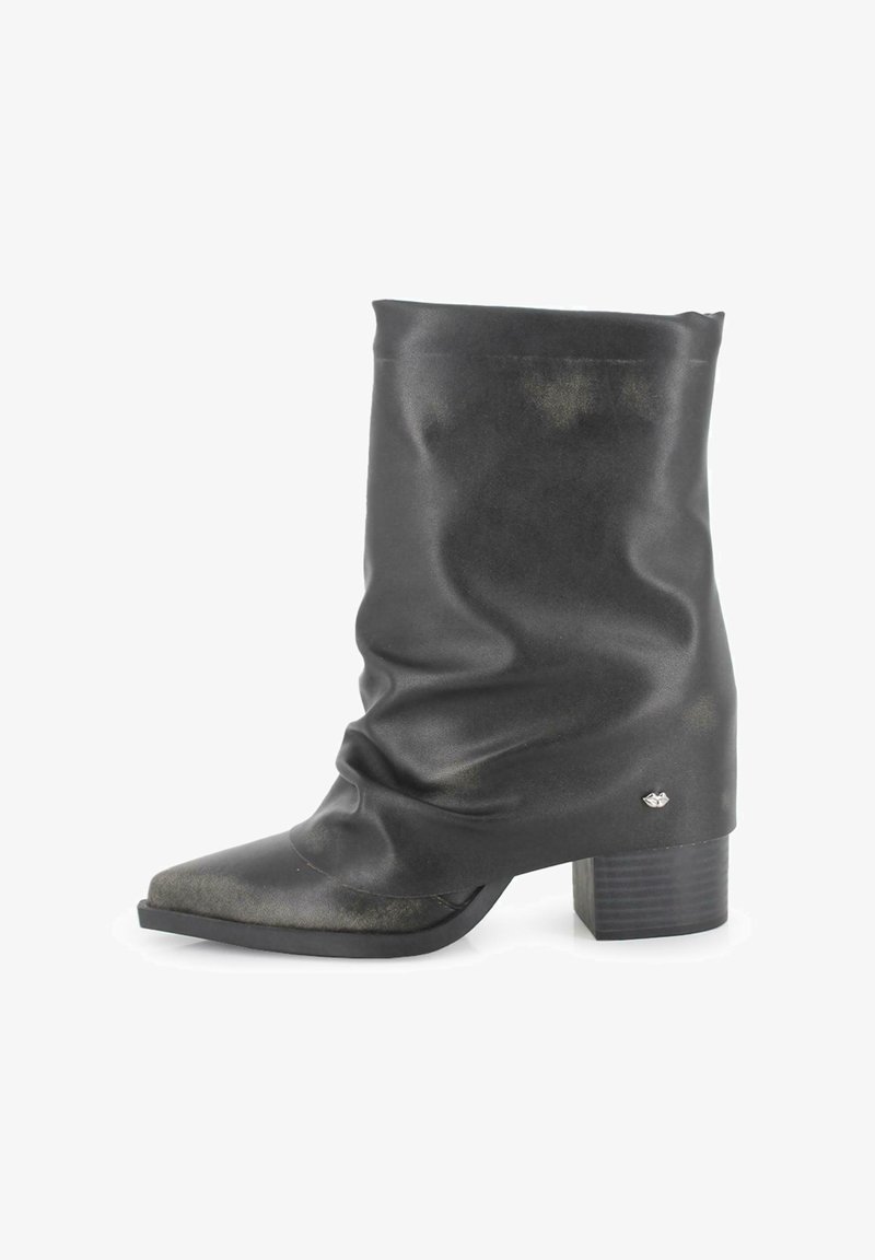 Botín negro de estilo informal hasta el tobillo, fabricado en material sintético suave, con puntera puntiaguda, tacón cuadrado y un pequeño detalle metálico en el costado.