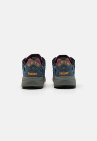 Niebieskie i szare buty sportowe z czarnymi akcentami, z napisem "SAUCONY" i "GRID" w pomarańczowym na pięcie, teksturowana cholewka i trwała podeszwa.