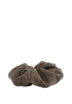 Chouchou en tissu à carreaux marron et beige avec une forme circulaire froncée sur fond blanc.