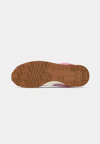 Pink and cream sneaker sole with textured rubber for grip, featuring a zigzag tread pattern and the "Converse" logo embossed.