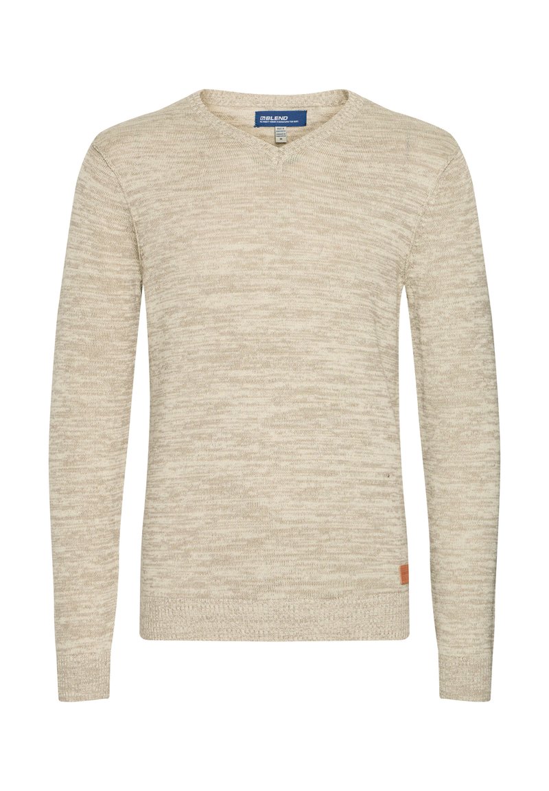 Beige neulotussa sweaterissä on V-pääntie, pitkät hihat, hienovarainen rakenne ja pieni logotagi vasemmassa alareunassa.