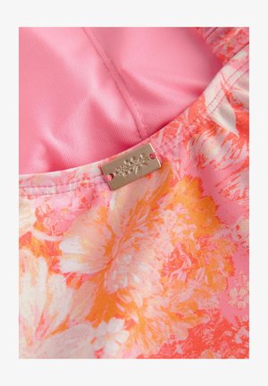 Floral fabric in pink, orange, and white with a smooth texture, featuring a metallic tag attached with floral design details.
