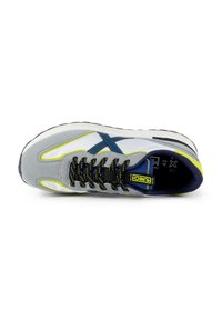 Baskets de sport grises avec des accents bleus et des touches jaunes. Présentent une tige en maille, une semelle intermédiaire blanche épaisse et des lacets noirs.