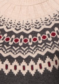 Beige und dunkelgrauer gestrickter Pullover mit geometrischen und kreisförmigen roten, weißen und grauen Mustern über der Brust und am Ausschnitt.