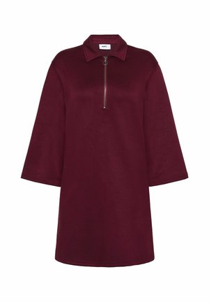 Rochie de un roșu închis, cu mâneci ample până la trei sferturi, guler și un fermoar scurt în față cu un tab de tip circular.