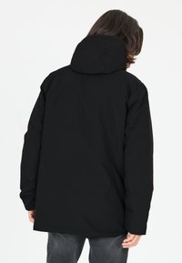 Sort isoleret jakke med hætte, med en glat tekstur og lige snit. Har sidelommer, minimal detaljering og en mat finish.