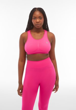 Reggiseno sportivo rosa brillante e leggings a vita alta coordinati, entrambi realizzati in tessuto elastico e traspirante con una texture liscia.