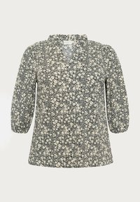 Kwiatowa bluzka z dekoltem w kształcie litery V, rękawami o długości trzy czwarte, na czarnym tle, z białym kwiatowym wzorem oraz marszczonym detalem w okolicy dekoltu. Materiał bawełniany.