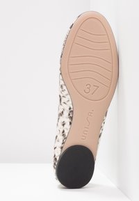 Textured beige and brown woven shoe with a flexible rubber grip sole, stamped size 37, and a smooth, light-colored base.