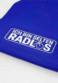 Blue knit beanie with a textured finish, featuring a white rectangular patch with the text "ICH BIN SELTEN RADLÖS" and a bicycle icon.