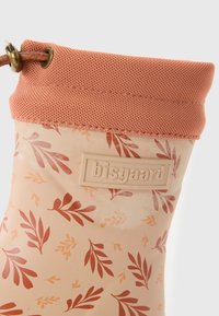Botte de pluie en caoutchouc pêche avec un motif floral dans des teintes de rouge et d'orange, bord supérieur texturé en maille et étiquette de marque en relief sur le côté.
