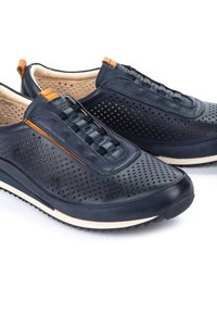 Scarpe in pelle blu con design perforato, dettagli con lacci elastici, accenti color cuoio e suola in gomma testurizzata, adatte per un uso casual.