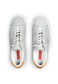Graue Leder-Sneaker mit weißen Schnürsenkeln und Gummisohlen. Merkmale sind ein hellbrauner Akzent an der Ferse und ein rotes Logo auf der Innensohle. Glatte Textur.