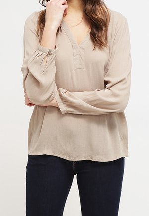 Beige, leichte Bluse mit V-Ausschnitt, langen Ärmeln mit gesammelten Bündchen und lockerem Schnitt. Weicher, strukturierter Stoff mit minimalen Details.