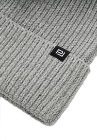 Szara dzianinowa czapka beanie o prążkowanej fakturze, z podwiniętym brzegiem i małą czarną metką z logo. Wykonana z grubego włóczki dla zapewnienia ciepła.