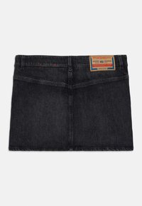 Shorts en denim noir à coupe droite, avec des coutures visibles et une patch en cuir brun portant l'inscription "Diesel Industry" à l'arrière.