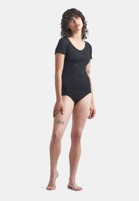 Black short-sleeve bodysuit made of soft fabric, featuring a scoop neckline and a fitted design, complementing the body's silhouette.